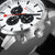 Nahaufnahme Zifferblatt: weißes Tastenlayout, schwarze Chronographenzähler, rote Akzentzeiger.