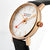 Herrenuhr Nahansicht mit roségoldenem Gehäuse, schwarzem Lederband und weißem Zifferblatt