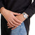 Damenuhr mit silbernem Metallarmband und weißem Zifferblatt am Handgelenk