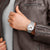 Mondaine Herrenarmbanduhr am Handgelenk mit silbernem Meshband und weißem Zifferblatt