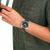 Mondaine Herrenuhr am Handgelenk: grünes Zifferblatt, Leder-/Textilarmband grün, silbernes Gehäuse