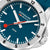 Cadran de montre pour homme en détail : bleu foncé, index blancs et trotteuse rouge.