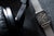 Montre homme sur bracelet, maille argentée, boîtier carré avec cadran sombre