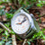Montre homme avec boîtier argenté, cadran blanc et bracelet en toile verte, couronne visible