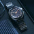 Montre bracelet pour homme au poignet avec bracelet noir et cadran bleu