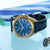 Herrenarmbanduhr mit blauem Zifferblatt, goldfarbener Lünette und dunkelblauem Lederarmband