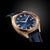 Herrenarmbanduhr mit rundem goldfarbenem Gehäuse, blauem Zifferblatt und blauem Lederarmband