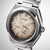 Gros plan d'une montre pour homme : boîtier argenté, cadran marron avec affichage de la date