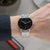 Montre pour homme au poignet : cadran noir, aiguilles rouges, bracelet en maille argentée
