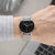 Montre homme avec cadran noir et bracelet en métal argenté, vue latérale