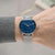 Montre bracelet pour homme au poignet avec cadran bleu et bracelet en maille argentée