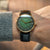 Montre pour homme au poignet : cadran vert, boîtier doré, bracelet en cuir noir