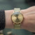 Montre pour femme au poignet avec bracelet milanais doré et cadran beige clair