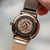 Fond de montre femme : boîtier rond couleur or rose avec gravure, bracelet milanais