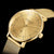 Montre pour femme en gros plan avec boîtier doré, cadran beige clair et bracelet en maille