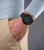 Chronograph am Handgelenk mit schwarzem Lederarmband und blauem Zifferblatt