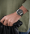 Herrenarmbanduhr am Handgelenk: braunes Lederarmband und schwarzes Zifferblatt
