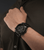 Herrenarmbanduhr am Handgelenk, schwarzes Kautschukband und markantes Ziffernblatt