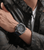 Herrenarmbanduhr Police am Handgelenk mit blauem Silikonband und grauem Gehäuse.