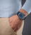 Herrenarmbanduhr am Handgelenk: blaues Armband, silbernes Gehäuse mit blauem Zifferblatt