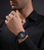 Herrenuhr am Handgelenk: blaues Silikonarmband und schwarzes Zifferblatt mit Chronograph