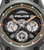 Uhr-Detail: schwarzes Zifferblatt mit orangefarbenen Akzenten und Chronografen-Subdials, Police
