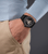 Herrenuhr am Handgelenk mit schwarzem Zifferblatt und schwarzem Armband