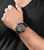 Herrenarmbanduhr am Handgelenk mit braunem Lederband und schwarzer Multifunktionsansicht