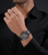 Herren-Armbanduhr am Handgelenk mit Metallband und Chronographen-Anzeige im Hemd