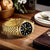 Goldfarbene Herrenuhr mit schwarzem Zifferblatt, Datumfenster und Edelstahlarmband