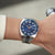 Armbanduhr am Handgelenk mit dunkelblauem Zifferblatt, Edelstahlarmband und Datumsfenster