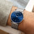 Herrenarmbanduhr am Handgelenk mit blauem Zifferblatt und Metall-Mesharmband