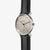 Montre pour homme de face : cadran beige avec échelle des heures, bracelet en cuir noir.