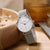 Montre pour femme au poignet avec cadran blanc et bracelet en maille argentée
