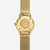 Dos d'une montre dorée pour femme avec fond rond et bracelet en maille