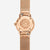 Vue arrière d'une montre pour femme avec boîtier couleur or rose, gravure sur le fond, bracelet en maille