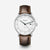 Montre avec bracelet en cuir marron foncé, boîtier rond argenté et cadran blanc.
