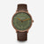 Montre unisexe avec boîtier rond, cadran vert et bracelet en cuir marron.