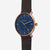 Montre homme avec cadran bleu, boîtier couleur or rose et bracelet en cuir marron.