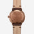 Montre homme avec boîtier couleur or rose et bracelet en cuir beige, fond gravé.