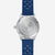 Dos d'une montre bracelet pour homme : boîtier argenté avec relief et bracelet bleu.