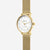 Montre dorée pour femme de profil, boîtier rond avec bracelet en maille