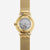 Montre élégante pour femme en or avec mouvement visible par le fond en verre et bracelet en maille
