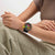 Swatch Armbanduhr am Handgelenk mit schwarzem Band und farbigem Chronograph-Zifferblatt