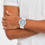 Herrenarmbanduhr am Handgelenk: weißes Band, blaues Skelett-Zifferblatt, Swatch