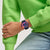 Swatch Armbanduhr am Handgelenk, blaues Band mit farbigen Anzeigen