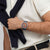 Armbanduhr am Handgelenk mit blauem Silikonarmband und orangefarbenem Zifferblatt