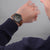 Uhr am Handgelenk mit braunem Lederband und schwarzem Zifferblatt