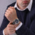 Herrenuhr am Handgelenk mit schwarzem Lederarmband und blauem Zifferblatt