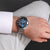 Herrenarmbanduhr am Handgelenk, Metallarmband, rundes blaues Zifferblatt